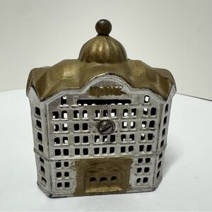 This is an antique cast iron still bank, specifically a "Domed Bank" building